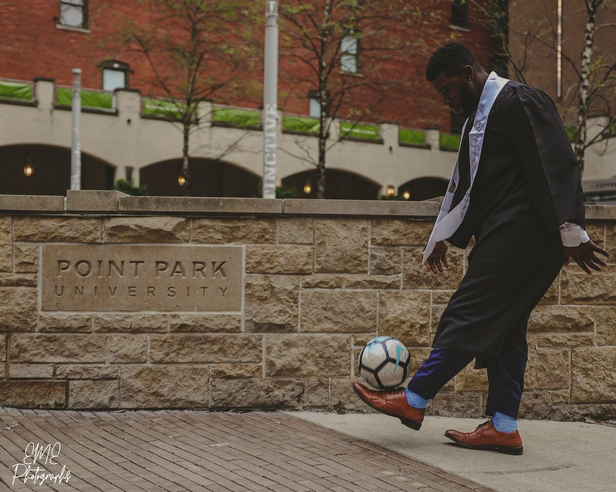 Juggling a ball in cap and gown at Point Park